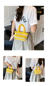 Detail of woven tote bag featuring yellow stripes and a silver metal chain strap