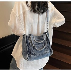 Woman carrying a vintage blue washed denim tote bag on a wooden staircase indoors