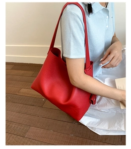 Dettaglio borsa shopper in pelle rossa con trama a grana e tracolla regolabile