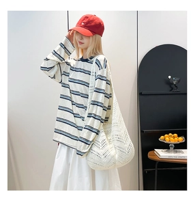 Macro shot of white hollow woven tote bag paired with striped long sleeve t-shirt