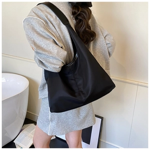 Detail shot of a black nylon shoulder bag with wide strap for stylish daily commuting