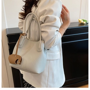 Détail du sac seau texturé avec un charmant pendentif éléphant en cuir souple