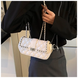 Close-up of white quilted crossbody bag with silver chain strap and metal clasp detail