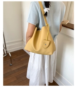 Dettaglio della borsa tote gialla con texture in pelle a grana e tracolla ampia