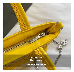 Detailed macro view of yellow crochet bag with silver metal zipper and floral charms
