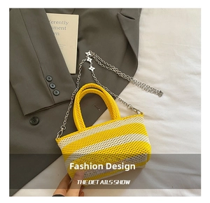 Detail showing yellow and cream knitted stripes and metal chain strap with clover motifs