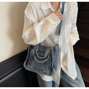 Detail of blue denim tote bag with adjustable strap and dual handles for daily use