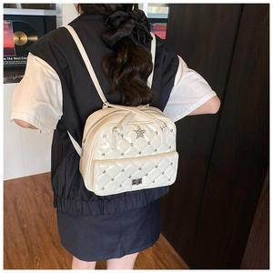 Detail of white quilted PU leather backpack with silver studs and star embellishment