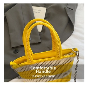 Detail showing the yellow woven handle and silver chain strap of the striped handbag