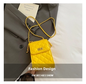 Macro detail of yellow quilted crossbody bag with gold twist lock and chain strap