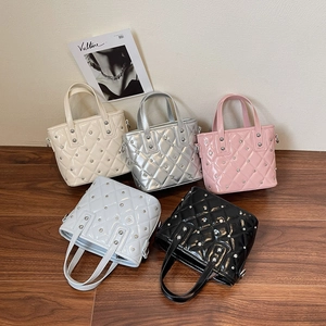 Chic quilted bucket bags with rivets in five colors shown on a stylish wooden floor