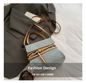 Detail of blue denim and brown leather straps on a stylish vintage crossbody bag