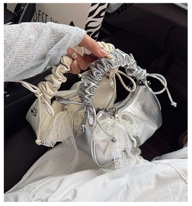 Détails des sacs à main plissés avec des pompons en perles et des nœuds en dentelle