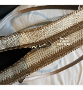 Detail of a smooth metal zipper and woven texture on a straw tote bag for beach