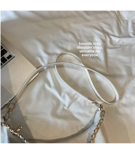 Detailed shot of white lychee pattern leather handbag with gold chain and adjustable strap