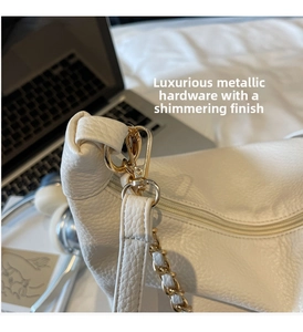 Close-up of white lychee pattern leather underarm bag with gold chain and metal buckles