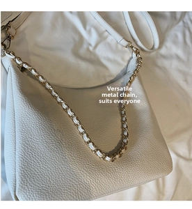 Detail of white lychee leather hobo bag with decorative gold chain strap and smooth texture