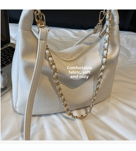 Detailed view of white lychee grain leather hobo bag with gold chain and leather straps