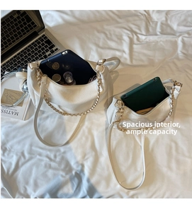 Detail showing white lychee pattern leather bags and interior space for personal items