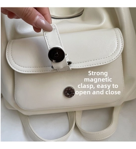Detail view of strong magnetic buckle closure on a minimalist cream tote bag