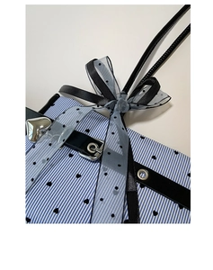 Close-up of blue striped bag with heart prints and polka dot mesh bow detail