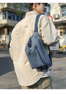 Detail of adjustable nylon strap and blue denim texture on the casual crossbody chest bag