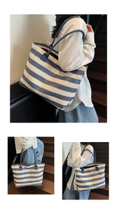 Detailed close-up of blue and white striped woven tote bag with slim blue shoulder straps