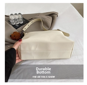 Vue détaillée du fond résistant à l'usure d'un sac à bandoulière crème minimaliste