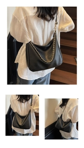Detailed views of a black lychee texture dumpling bag with gold chain on a wooden staircase