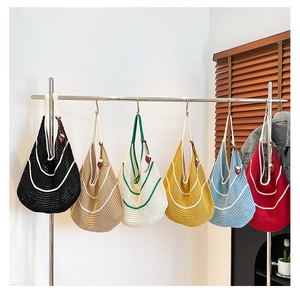 Detail of colorful knitted hobo bags with strawberry pendants on a metal rack display