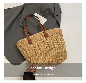 Macro detail showing woven texture of straw tote bag with brown leather handles