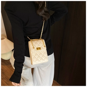 Detail of cream quilted phone bag with gold chain strap and metal turn-lock closure