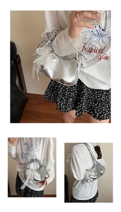 Detail of metallic silver pleated cloud bag with pearl chain and lace bow decoration