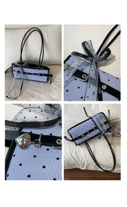 Detail of blue striped tote with black heart patterns and mesh polka dot bow