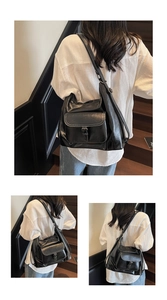 Detail of black vintage tote bag featuring retro buckle and white contrast stitching