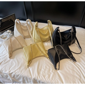 Detailed macro view of trendy textured crescent bags in white, yellow, and black colors