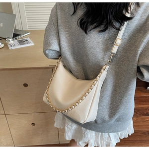 Detail of off-white lychee texture hobo bag with gold chain and adjustable strap