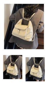 Detail of cream oversized tote backpack featuring vintage buckle and flap closure
