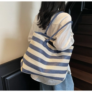 Vue détaillée du sac cabas tissé à rayures bleues et blanches montrant la texture