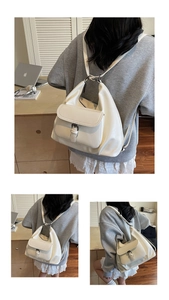 Close-up of minimalist cream tote with metal buckle and versatile shoulder straps