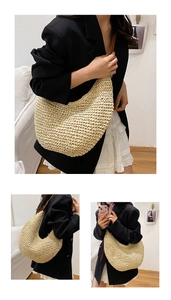 Detail showing woven texture and brown leather strap of the large straw hobo shoulder bag
