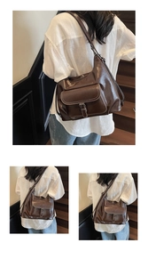 Detail of dark brown glossy leather tote bag with buckle flap pocket and adjustable strap