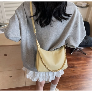 Detail of light yellow lychee pattern leather crescent bag with gold chain strap