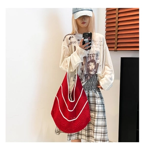 Detail of red and white crochet shoulder bag with hollow knit pattern and hobo style