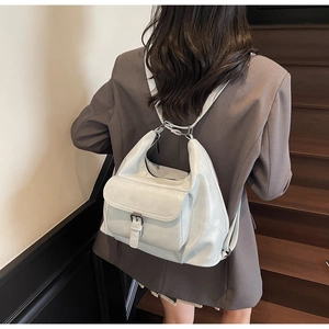 Detail of grey PU leather backpack with silver buckle pocket and textured finish