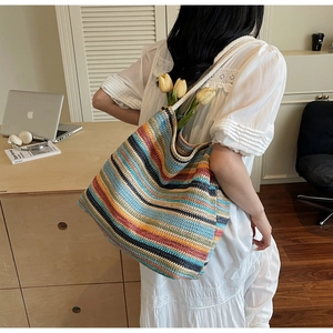 Gros plan d'un sac cabas en tricot rayé coloré avec poignées en corde de coton blanc