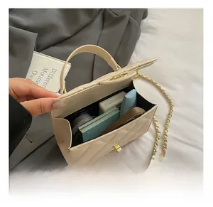 Interior view of beige quilted bag with gold hardware showing makeup storage capacity