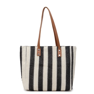 Handwoven black and white striped straw tote bag with brown faux leather handles for beach