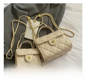 Detailed view of beige quilted leather chain bags in two sizes with gold turn-lock closure