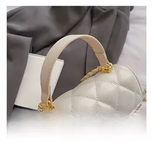 Detailed close-up of quilted rhombic leather texture and golden metal chain handle
